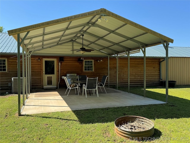exterior space featuring a ceiling fan, metal roof, a lawn, cooling unit, and a patio