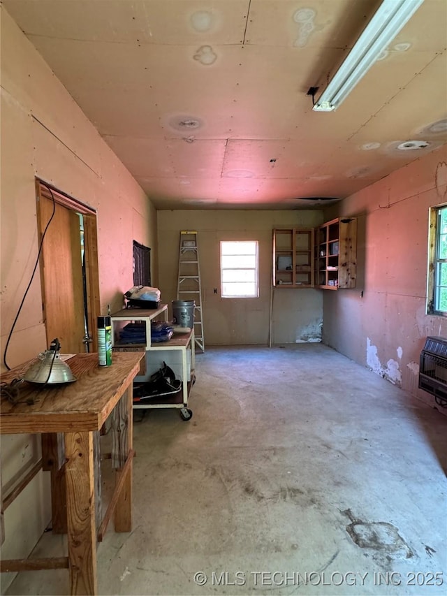 miscellaneous room featuring concrete flooring and heating unit