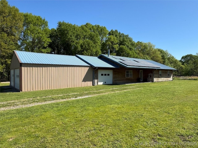 exterior space featuring board and batten siding, a yard, metal roof, and solar panels