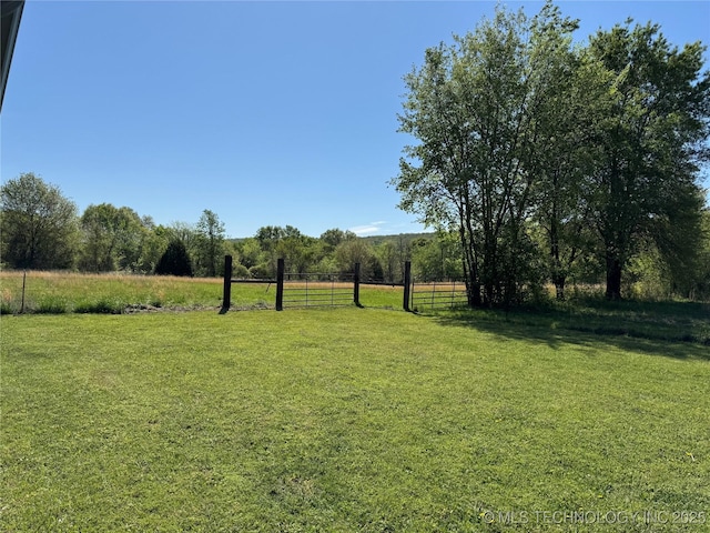 view of yard featuring a rural view and fence