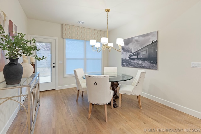 dining room with a chandelier, wood finished floors, baseboards, and visible vents
