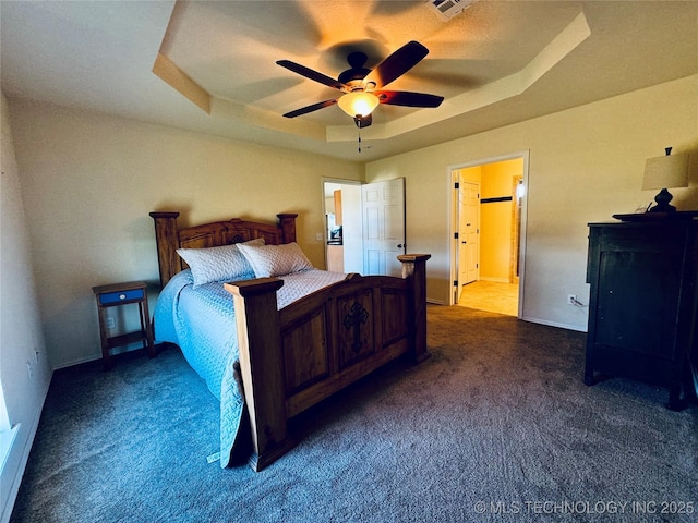 bedroom featuring baseboards, carpet flooring, a tray ceiling, and a ceiling fan