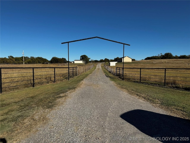 view of street featuring a rural view and gravel driveway