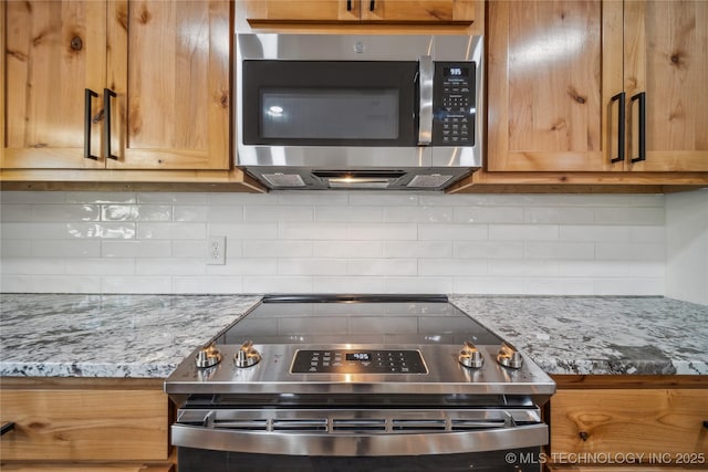 2615 E 59th St, Tulsa, OK 74105 - kitchen with appliances with stainless steel finishes, light stone counters, and tasteful backsplash