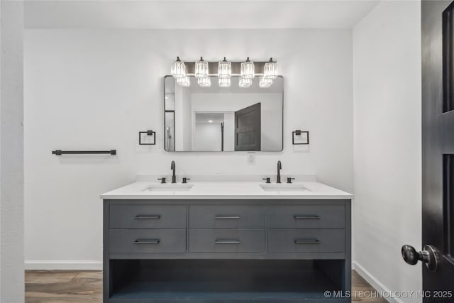 2615 E 59th St, Tulsa, OK 74105 - bathroom featuring double vanity, a sink, baseboards, and wood finished floors