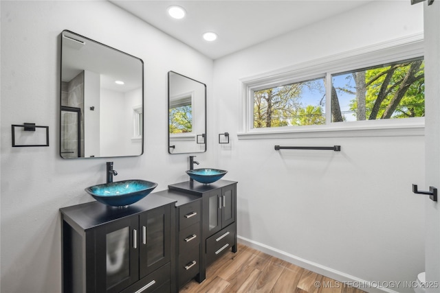 2615 E 59th St, Tulsa, OK 74105 - bathroom featuring double vanity, a stall shower, a sink, and wood finished floors