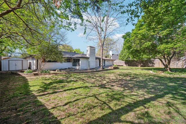 2615 E 59th St, Tulsa, OK 74105 - view of yard featuring a storage shed, fence, and an outbuilding