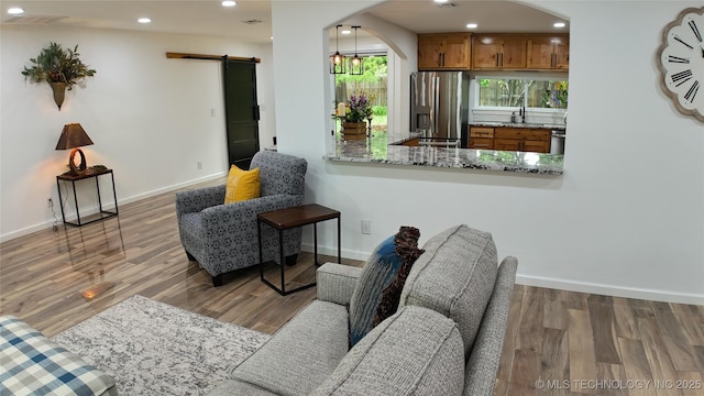 2615 E 59th St, Tulsa, OK 74105 - living room featuring arched walkways, baseboards, and a barn door
