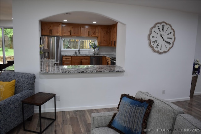 2615 E 59th St, Tulsa, OK 74105 - kitchen featuring brown cabinets, a sink, arched walkways, stainless steel appliances, and dark wood-type flooring