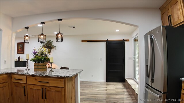 2615 E 59th St, Tulsa, OK 74105 - kitchen featuring brown cabinets, light stone countertops, stainless steel refrigerator with ice dispenser, and a wealth of natural light