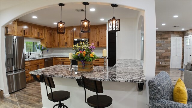 2615 E 59th St, Tulsa, OK 74105 - kitchen featuring visible vents, a sink, a peninsula, arched walkways, and stainless steel appliances