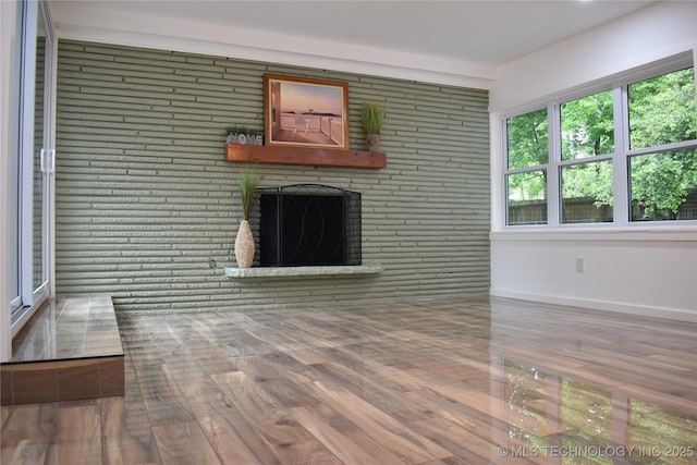 2615 E 59th St, Tulsa, OK 74105 - unfurnished living room with baseboards, a brick fireplace, and wood finished floors