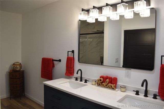 2615 E 59th St, Tulsa, OK 74105 - bathroom featuring double vanity, a marble finish shower, a sink, and wood finished floors