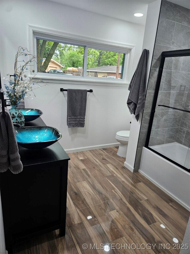 2615 E 59th St, Tulsa, OK 74105 - full bath featuring a healthy amount of sunlight, vanity, toilet, and wood finished floors