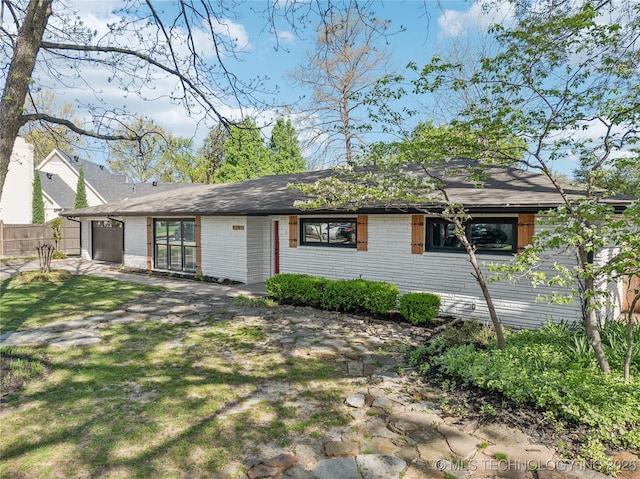 2615 E 59th St, Tulsa, OK 74105 - view of front facade featuring brick siding, fence, and a garage