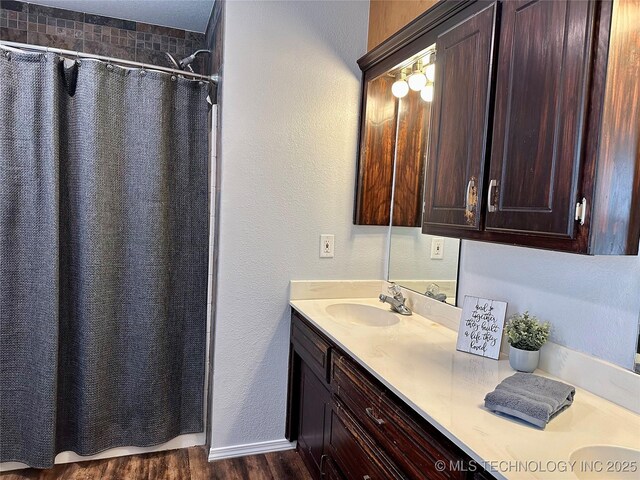 4665 Primrose, Sulphur, OK 73086 - full bathroom with double vanity, a shower with curtain, wood finished floors, and a textured wall