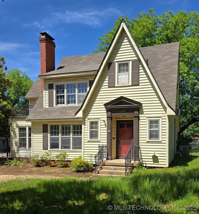 1303 N 6th, Durant, OK 74701 - view of front of house with a chimney, cooling unit, and a shingled roof