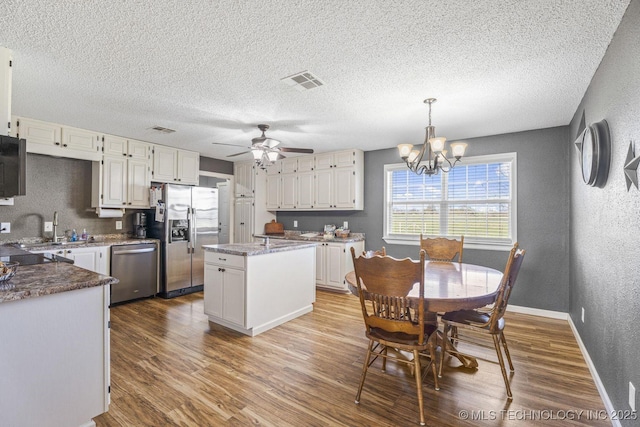 9720 S 4475th Rd, Miami, OK 74354 - kitchen with appliances with stainless steel finishes, wood finished floors, a textured wall, and a textured ceiling