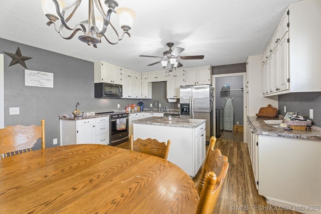 9720 S 4475th Rd, Miami, OK 74354 - kitchen with ceiling fan with notable chandelier, dark wood finished floors, a center island, a sink, and stainless steel appliances