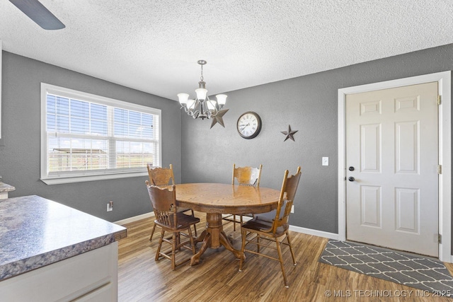 9720 S 4475th Rd, Miami, OK 74354 - dining room featuring a textured wall, a chandelier, wood finished floors, and a textured ceiling