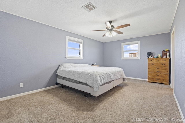 9720 S 4475th Rd, Miami, OK 74354 - bedroom with a ceiling fan, a textured ceiling, multiple windows, and visible vents