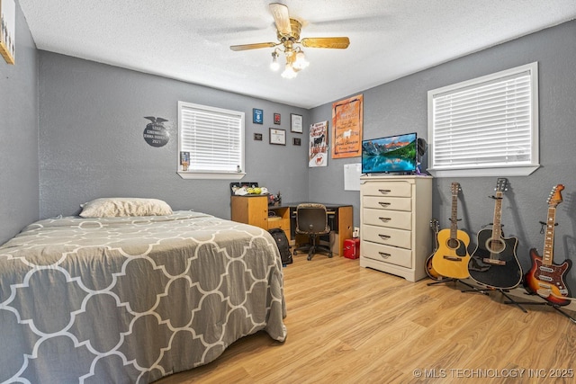 9720 S 4475th Rd, Miami, OK 74354 - bedroom featuring light wood-style flooring, a textured ceiling, a textured wall, and a ceiling fan