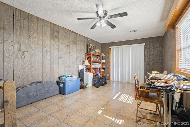 9720 S 4475th Rd, Miami, OK 74354 - dining area with visible vents, ceiling fan, a textured ceiling, wood walls, and tile patterned floors