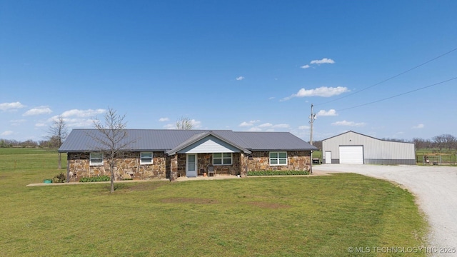 9720 S 4475th Rd, Miami, OK 74354 - single story home with stone siding, metal roof, a garage, an outbuilding, and a front lawn