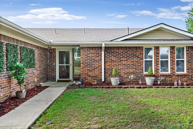 2909 Haddock Dr, Muskogee, OK 74401 - property entrance featuring brick siding, a shingled roof, and a lawn