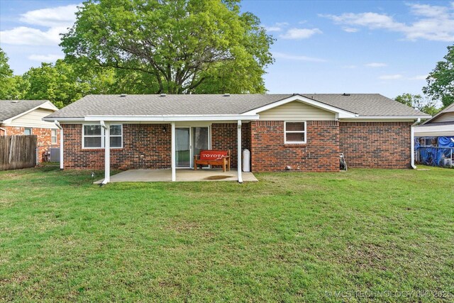 2909 Haddock Dr, Muskogee, OK 74401 - rear view of property featuring brick siding, a patio, a yard, and fence