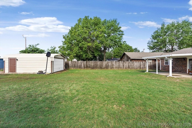 2909 Haddock Dr, Muskogee, OK 74401 - view of yard featuring a detached garage, a patio, an outbuilding, and a fenced backyard