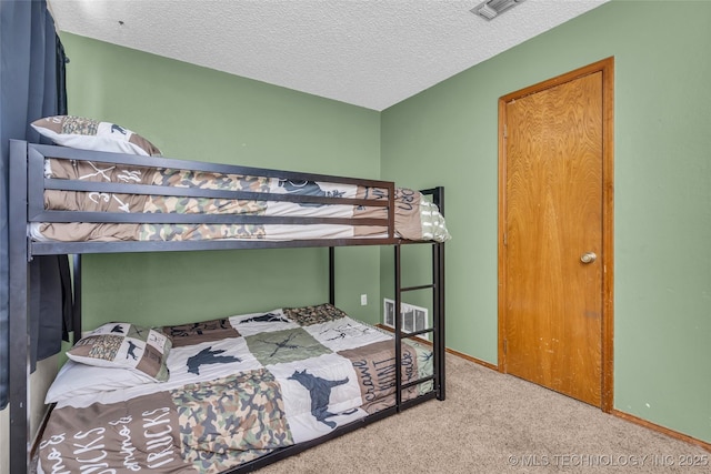 carpeted bedroom featuring visible vents, a textured ceiling, and baseboards