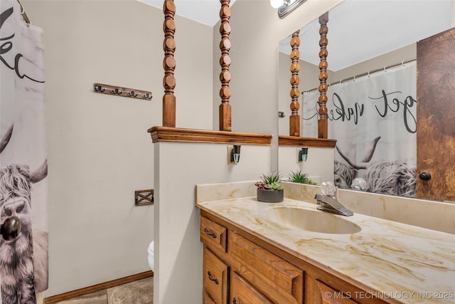 bathroom with toilet, curtained shower, vanity, and baseboards