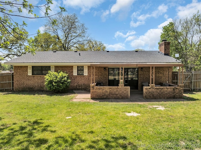 back of house featuring a patio area, a yard, fence, and a chimney