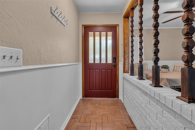doorway with brick floor and a ceiling fan