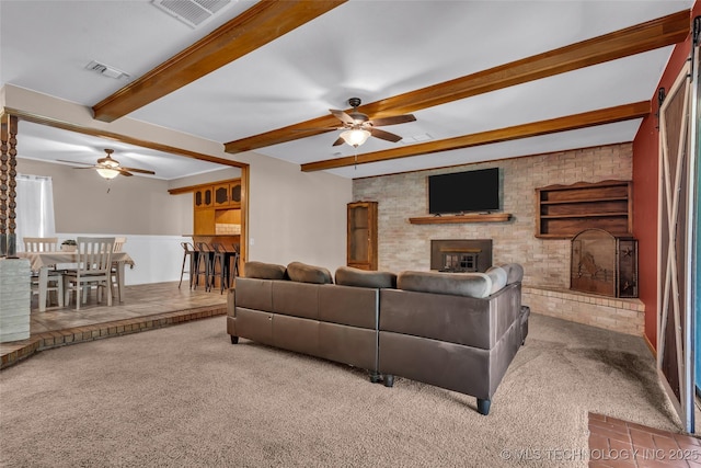 carpeted living area with visible vents, a ceiling fan, and a brick fireplace
