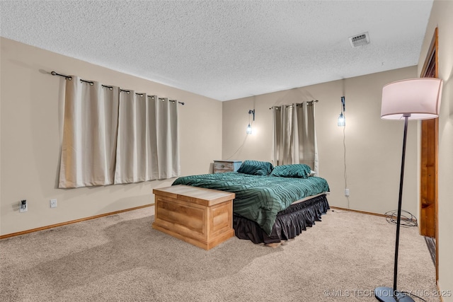 carpeted bedroom with visible vents, baseboards, and a textured ceiling