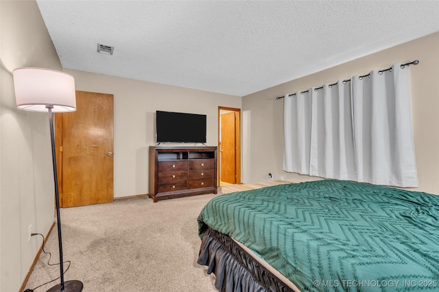 bedroom with a textured ceiling, carpet flooring, and visible vents