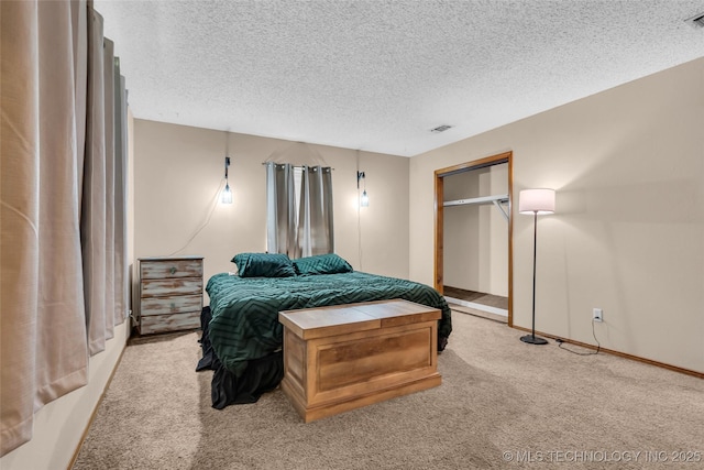 bedroom with visible vents, light colored carpet, and a textured ceiling