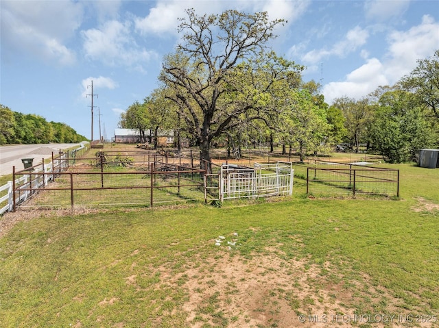 view of yard with fence and a rural view