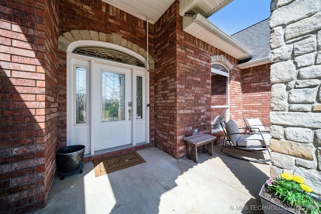 doorway to property with brick siding