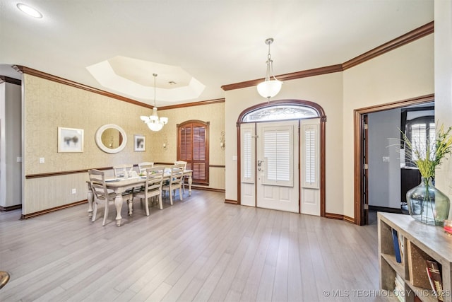 entrance foyer featuring crown molding, baseboards, a notable chandelier, and wood finished floors
