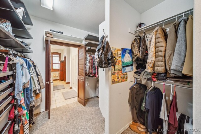 walk in closet with tile patterned flooring and carpet