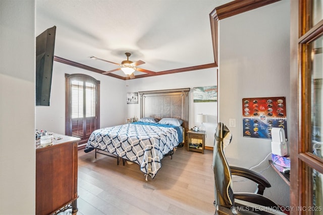 bedroom with crown molding, a ceiling fan, and wood finished floors