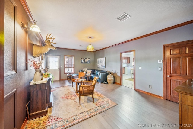 dining area featuring crown molding, visible vents, baseboards, and wood finished floors