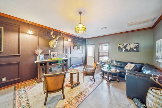 living room featuring crown molding, visible vents, and wood finished floors