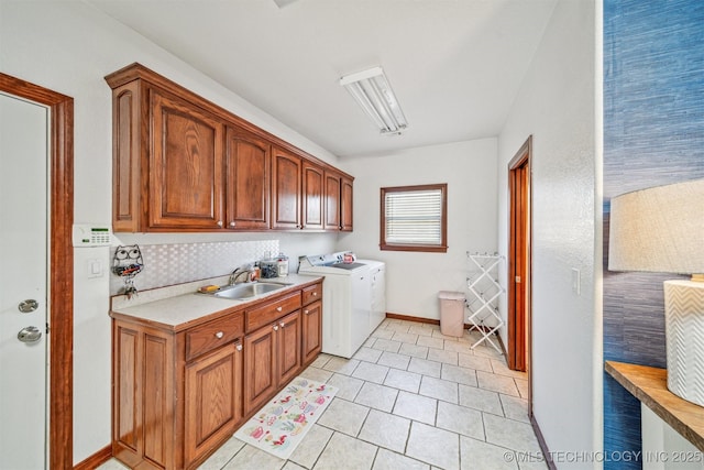 washroom featuring baseboards, light tile patterned floors, cabinet space, washer and dryer, and a sink