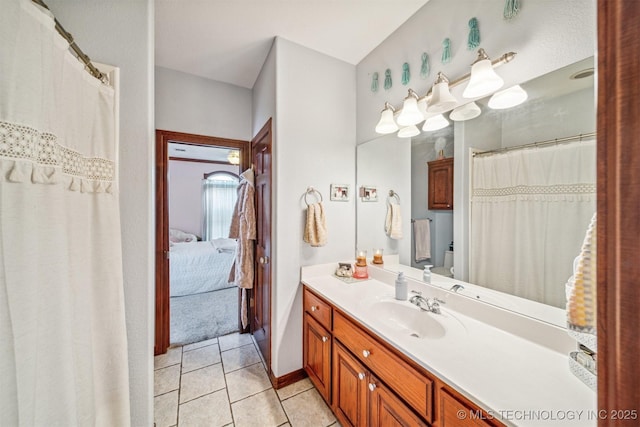 ensuite bathroom featuring ensuite bathroom, baseboards, tile patterned flooring, and vanity