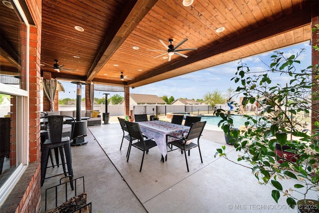 view of patio / terrace featuring a fenced backyard, a ceiling fan, a fenced in pool, and outdoor dining area