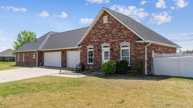 traditional-style home featuring driveway, an attached garage, a front yard, brick siding, and fence